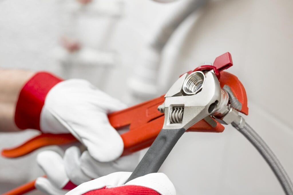 Plumber holding pipe wrenches for an emergency repair in Edgewater
