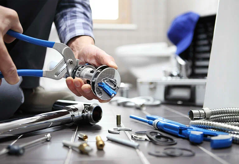 Technician repairing a plumbing fixture with professional tools in Edgewater