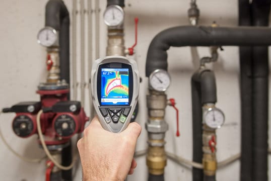 Plumber using a thermal imaging camera to inspect pipes in Edgewater