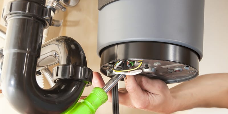 Technician repairing the heating element of a water heater in Edgewater