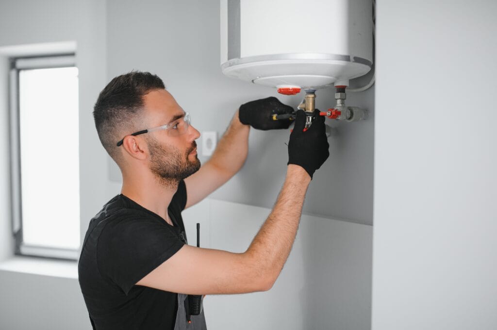 Technician performing water heater maintenance in Edgewater