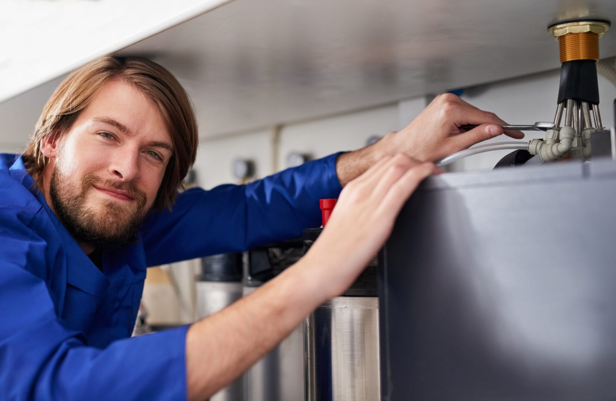 Technician servicing a residential water heater tank in Edgewater
